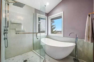 a bathroom with a tub and a glass shower at The Royal Ravine Luxury Retreat with Hot Tub & Sauna in Calgary
