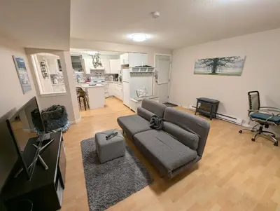 a living room with a couch and a kitchen at Walnut Grove Gem in Langley