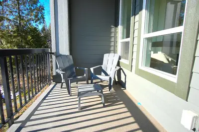 two chairs sitting on the porch of a house at Peaceful Coquitlam Escape, Modern New Home, Minutes to Transit in Coquitlam