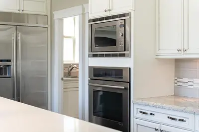 a kitchen with stainless steel appliances and white cabinets at Sunnymede Vacation Stay in Richmond