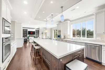 a large kitchen with white cabinets and a large island at Sunnymede Vacation Stay in Richmond