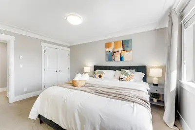 a white bedroom with a large bed with white walls at Sunnymede Vacation Stay in Richmond