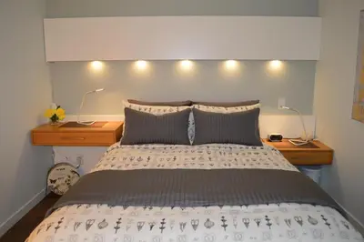 a bedroom with a bed with two night stands and two lamps at Be Close To Chinatown When You Are In The Union Building in Victoria