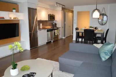 a living room and kitchen with a couch and a table at Be Close To Chinatown When You Are In The Union Building in Victoria