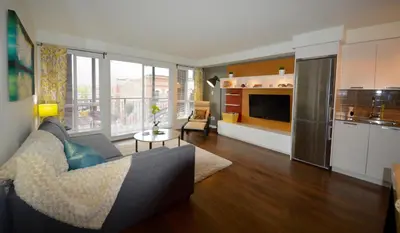 a living room with a couch and a kitchen at Be Close To Chinatown When You Are In The Union Building in Victoria