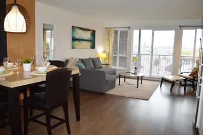 a living room with a couch and a table with chairs at Be Close To Chinatown When You Are In The Union Building in Victoria