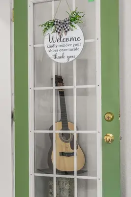 a guitar in a door with a sign on it at Downtown Den - Steps Away from Worlds Largest Dino in Drumheller