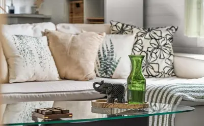 a green bottle on a glass table in front of a couch at Downtown Den - Steps Away from Worlds Largest Dino in Drumheller
