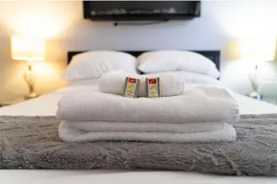 a pile of towels sitting on top of a bed at Cozy 1 Bedroom Downtown Central in Vancouver