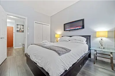 a bedroom with a large bed with a tv on the wall at Cozy 1 Bedroom Downtown Central in Vancouver