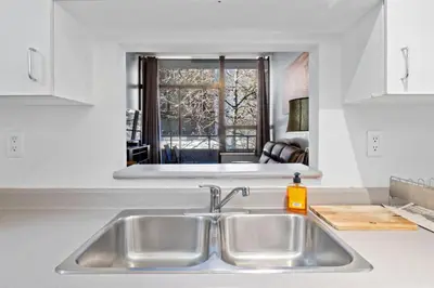a kitchen counter with a sink and a mirror at Cozy 1 Bedroom Downtown Central in Vancouver