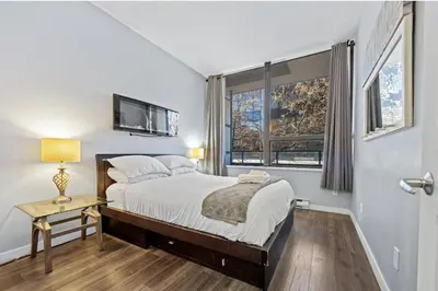 a bedroom with a bed and a window at Cozy 1 Bedroom Downtown Central in Vancouver