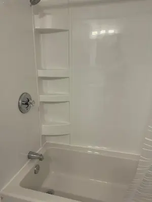 a white bathroom with a tub and a glass shower at 2bedroom, 2bed day light Suite in a nice and secured neighborhood in Prince George
