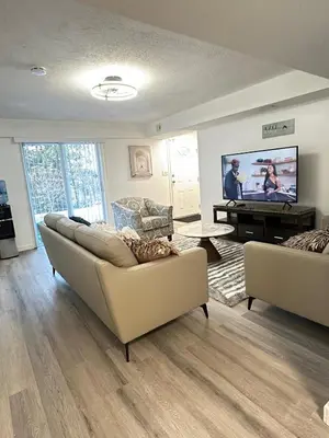a living room with two couches and a flat screen tv at 2bedroom, 2bed day light Suite in a nice and secured neighborhood in Prince George