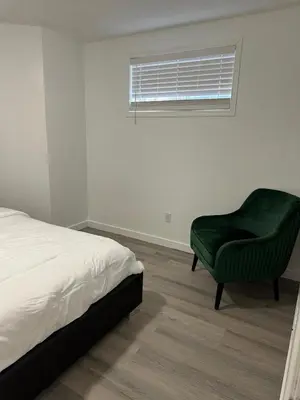 a bedroom with a bed and a green chair at 2bedroom, 2bed day light Suite in a nice and secured neighborhood in Prince George