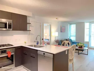 a kitchen with a sink and a living room at Cozy Perfect &elegant 2bed 1 bath in Richmond center in Richmond