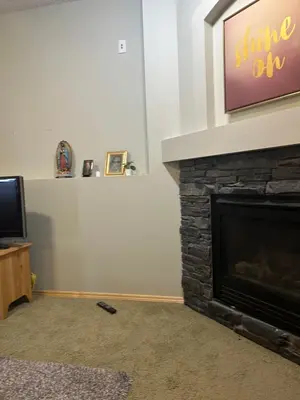 a living room with a fireplace and a tv at Unique home services in Bélanger