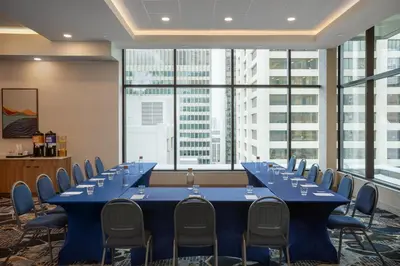 a conference room with blue tables and chairs and windows at Hampton Inn By Hilton Calgary Downtown in Calgary