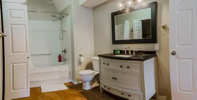 a bathroom with a sink and a toilet and a mirror at entire house THE BLUE DOOR with garage access in Grande Prairie