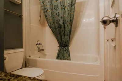 a bathroom with a toilet and a shower curtain at entire house THE BLUE DOOR with garage access in Grande Prairie