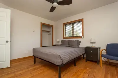 a bedroom with a bed and a blue chair at Pet Friendly 3 Bdrm Home with Hot Tub by StayIn in Fernie
