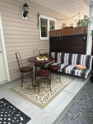 a patio with a table and chairs and a couch at Clean and Quiet 2 bdr 2 bthr private entrance entire guests suite near Coquitlam Center mall and skytrain in Coquitlam