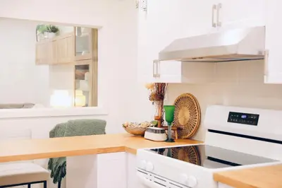a kitchen with white appliances and a wooden counter top at Little Nest in Calgary