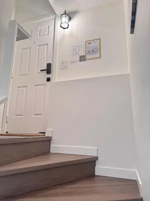 a stairway with a white door and wooden stairs at Little Nest in Calgary