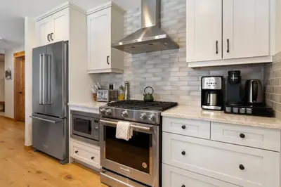 a kitchen with a stove and a refrigerator at Spring Creek Corner Condo by Canadian Rockies Vacation Rentals in Canmore