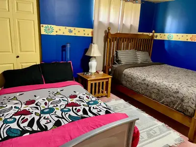 a bedroom with two beds and blue walls at Imperial Ranchettes GuestSuite in Lone Butte