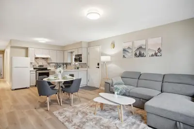 a living room with a couch and a table at 6 Bedroom Family Home with Indoor Arcade, BBQ, Huge Backyard & Pickleball in Vancouver