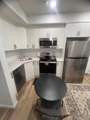 a kitchen with a black table and a refrigerator at Home sweet home in Calgary