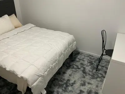 a bedroom with a white bed and a table at Home sweet home in Calgary