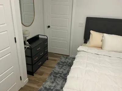 a bedroom with a bed and a dresser and a mirror at Home sweet home in Calgary