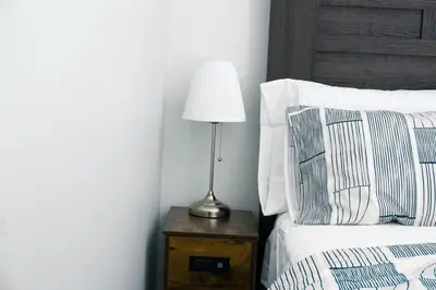 a lamp on a night stand next to a bed at Comfy & Modern 2 Bedroom Guest Suite with King Bed in Edmonton