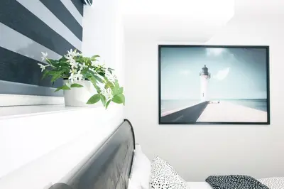 a living room with a picture of a lighthouse on the wall at Comfy & Modern 2 Bedroom Guest Suite with King Bed in Edmonton