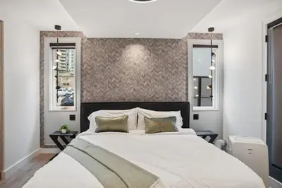 a bedroom with a large bed and two windows at Luxury Downtown Vancouver Home Near Sunset Beach with Parking in Vancouver
