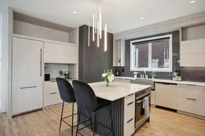 a kitchen with white cabinets and a table and chairs at Luxury Downtown Vancouver Home Near Sunset Beach with Parking in Vancouver