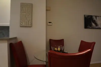 a dining room with a glass table and red chairs at Discover Tranquility in this 2 bed townhouse in Vancouver