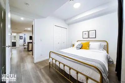 a bedroom with a large bed with yellow pillows at NEW-The Suite Life-2BD-King Bed-WEM & YEG Airport in Edmonton