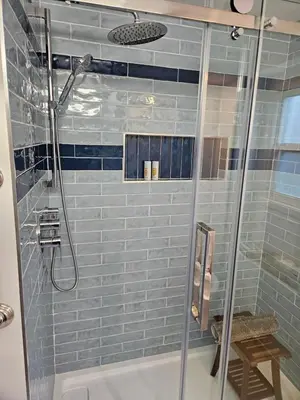 a bathroom with a shower with blue tile at D&G Suite Retreat in Sidney