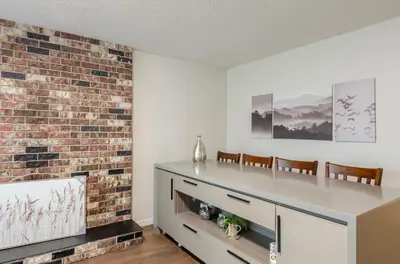a living room with a fireplace and a brick wall at Close to YVR! Convenient 3BR Stay for Every Occasion in Vancouver