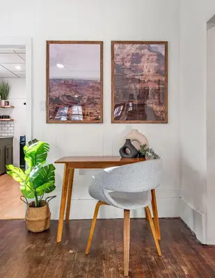 a desk with a chair and two pictures on the wall at The Sandlot Family in Drumheller