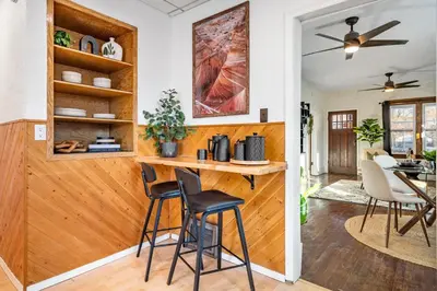 a kitchen and dining room with a bar with stools at The Sandlot Family in Drumheller