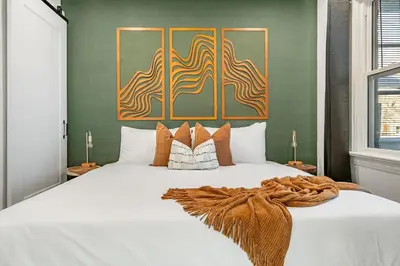 a bedroom with a large white bed with a blanket at The Sandlot Family in Drumheller