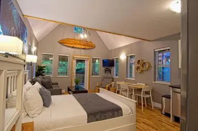 a bedroom with a bed and a living room at Tide and Trail- Cabin in Ucluelet in Ucluelet