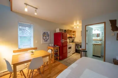 a kitchen and dining room with a table and chairs at Surf Haven - Cabin in Ucluelet - Sleeps 5 in Ucluelet
