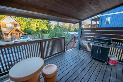 a deck with a stove and a table on it at Surf Haven - Cabin in Ucluelet - Sleeps 5 in Ucluelet