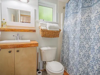 a bathroom with a toilet and a shower curtain at Surf Haven - Cabin in Ucluelet - Sleeps 5 in Ucluelet
