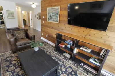 a living room with a television on a wooden wall at Raven Lady #201- Ucluelet Sleeps 6 Pet Friendly in Ucluelet